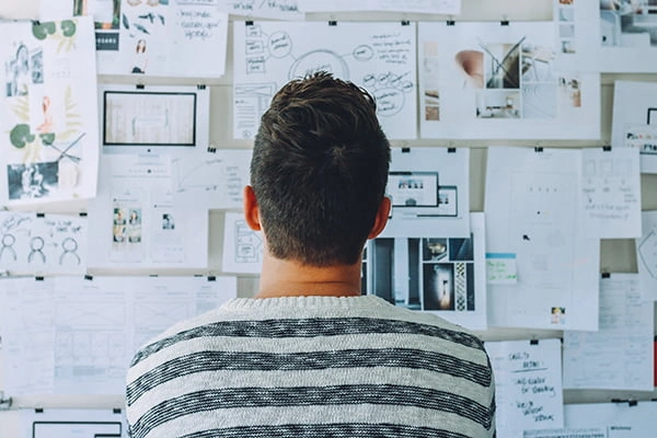 SEO for entrepreneurs: A man standing in front of a wall covered in papers.