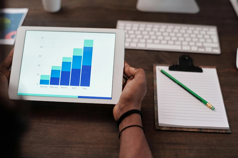 Man with tablet showing graphs on desk for digital marketing hotels