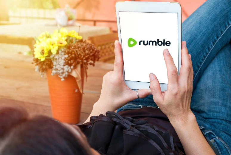 A woman navigating the Rumble platform on a tablet.