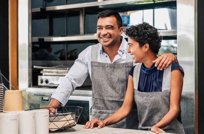SEO for small business cafe owners A man and woman stand behind a cafe counter, representing SEO for small business growth.